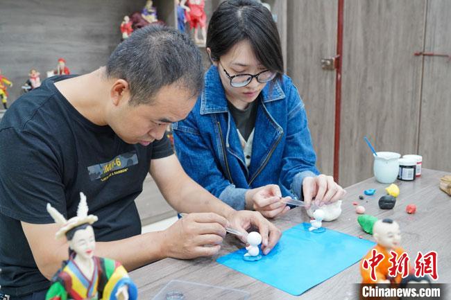 <a target='_blank'  data-cke-saved- >中新社</a>記者(右)現(xiàn)場(chǎng)體驗(yàn)面塑制作過(guò)程?！￡悹?zhēng)強(qiáng) 攝