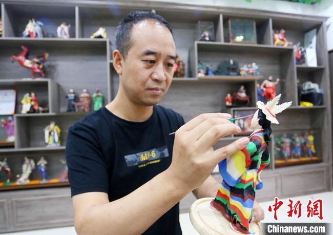 圖為安秋平正在創(chuàng)作代表隴南文縣民俗的《白馬人》作品?！「哒?攝