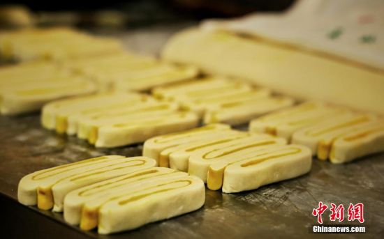 圖為面劑被涂上胡麻油，切成條狀用作月餅的花型制作。張文 攝