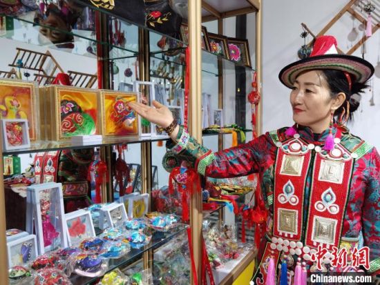 圖為身著民族服飾的隴原巧手展示手工藝品。(資料圖) 徐雪 攝