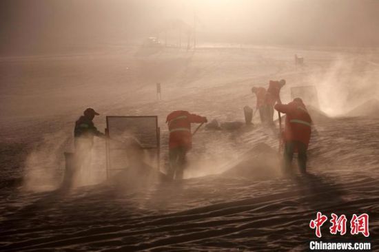 圖為敦煌市鳴沙山月牙泉景區(qū)“駱駝保姆”清理駱駝糞便?！垥粤?攝