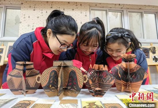 圖為學生用紙創(chuàng)作的立體彩陶?！⒂裉?攝