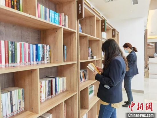 圖為在甘肅公航旅建設(shè)集團有限公司的職工書屋，職工挑選書籍?！⌒煅?攝