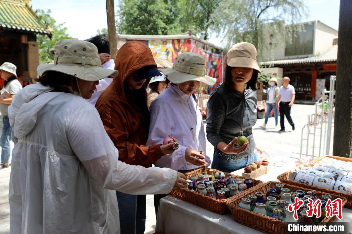 圖為民眾挑選手工藝產(chǎn)品?！⊙Φ?攝