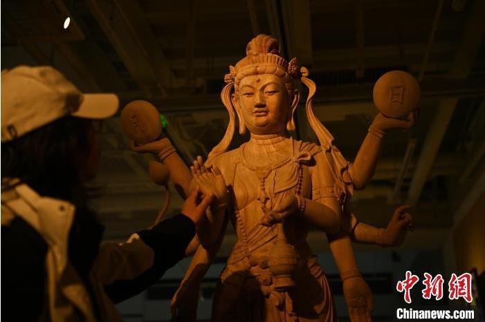 圖為季茂杰觀察自己創(chuàng)作的敦煌木雕。李亞龍 攝</p>
<p>