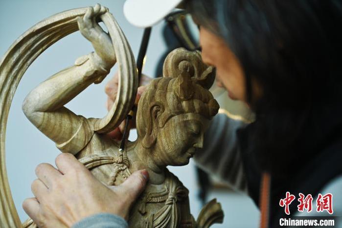 圖為季茂杰進行敦煌元素的木雕創(chuàng)作。李亞龍 攝</p>
<p>