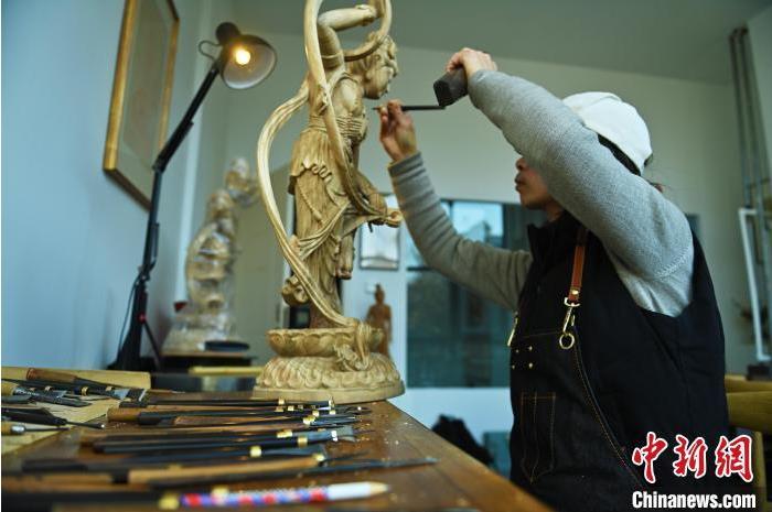 圖為季茂杰進行敦煌元素的木雕創(chuàng)作。李亞龍 攝</p>
<p>