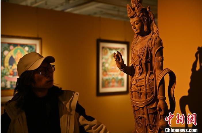 圖為季茂杰觀察自己創(chuàng)作的敦煌木雕。李亞龍 攝</p>
<p>