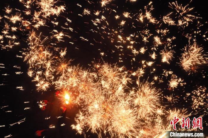 灼熱的鐵水在空中迸散。在空中形成“鐵花火雨”的景象，似天女散花，似群星漫天，如夢如幻，美不勝收。侯奇志 攝</p>
<p>