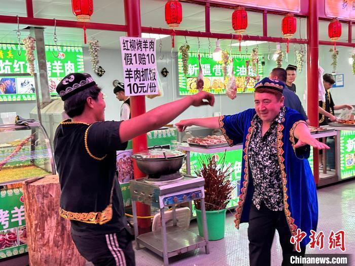 圖為餐飲經(jīng)營者在“西涼不夜城”跳起舞蹈引客。　戴文昌 攝</p><p>