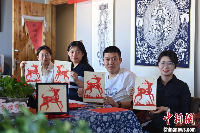 6月6日，在甘肅敦煌青年夜校課程中，青年學(xué)員展示學(xué)習(xí)敦煌非遺剪紙的成果。李亞龍 攝　　