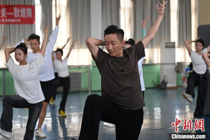 6月6日，在甘肅敦煌青年夜校課程中，青年學(xué)員學(xué)習(xí)敦煌舞課程。李亞龍 攝　　