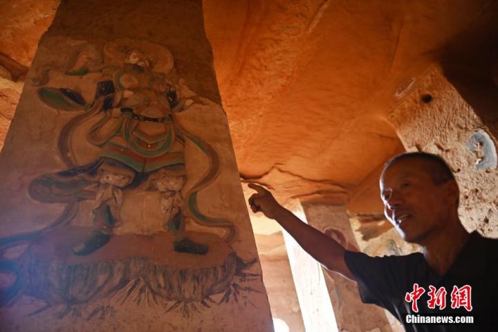 7月15日，甘肅省平?jīng)鍪袥艽h百里石窟長(zhǎng)廊羅漢洞石窟內(nèi)，該窟文保員郭建平介紹窟內(nèi)石刻彩繪壁畫(huà)。郭建平家中三代人曾自發(fā)保護(hù)羅漢洞石窟。羅漢洞石窟遺存40余個(gè)窟龕，以北魏至清代風(fēng)格為主。中新社記者 李亞龍 攝</p>
<p>