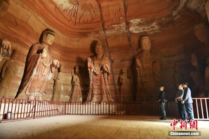 7月15日，游人參觀甘肅省平?jīng)鍪袥艽h百里石窟長(zhǎng)廊中的南石窟寺1號(hào)窟。百里石窟長(zhǎng)廊位于涇川縣境內(nèi)，由512個(gè)石窟、5眼窟中石井組成，現(xiàn)存王母宮石窟、鳳凰山石窟、南石窟寺、丈八寺石窟、羅漢洞石窟、太山寺石窟等規(guī)模較大的石窟群，還有數(shù)量眾多的小石窟群。南石窟寺開(kāi)鑿于北魏永平三年，其中1號(hào)窟屬于大型七佛窟，七佛高達(dá)6米。中新社記者 李亞龍 攝