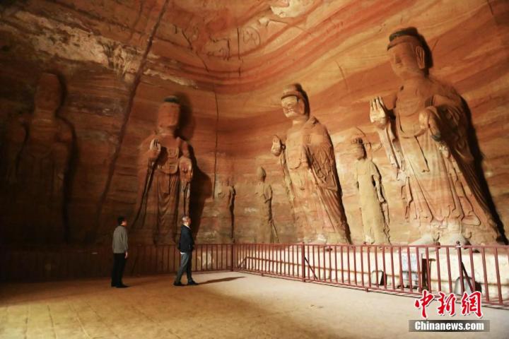 7月15日，游人參觀甘肅省平?jīng)鍪袥艽h百里石窟長(zhǎng)廊中的南石窟寺1號(hào)窟。百里石窟長(zhǎng)廊位于涇川縣境內(nèi)，由512個(gè)石窟、5眼窟中石井組成，現(xiàn)存王母宮石窟、鳳凰山石窟、南石窟寺、丈八寺石窟、羅漢洞石窟、太山寺石窟等規(guī)模較大的石窟群，還有數(shù)量眾多的小石窟群。南石窟寺開(kāi)鑿于北魏永平三年，其中1號(hào)窟屬于大型七佛窟，七佛高達(dá)6米。中新社記者 李亞龍 攝