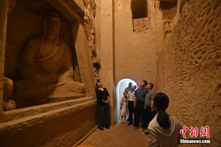 7月15日，游人參觀甘肅省平?jīng)鍪袥艽h百里石窟長(zhǎng)廊中的王母宮石窟。百里石窟長(zhǎng)廊位于涇川縣境內(nèi)，由512個(gè)石窟、5眼窟中石井組成，現(xiàn)存王母宮石窟、鳳凰山石窟、南石窟寺、丈八寺石窟、羅漢洞石窟、太山寺石窟等規(guī)模較大的石窟群，還有數(shù)量眾多的小石窟群。王母宮石窟又名千佛洞，該窟設(shè)計(jì)宏大，造像生動(dòng)，窟內(nèi)擁有造像數(shù)百尊，是較為珍貴的佛教文化歷史遺存。中新社記者 李亞龍 攝</p>
<p>