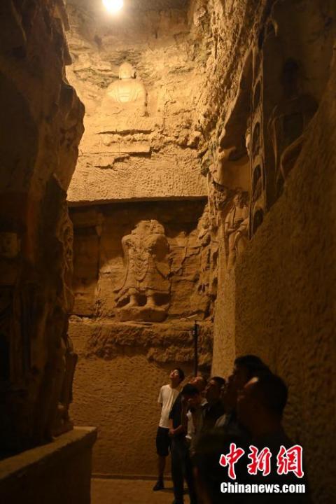 7月15日，游人參觀甘肅省平?jīng)鍪袥艽h百里石窟長(zhǎng)廊中的王母宮石窟。百里石窟長(zhǎng)廊位于涇川縣境內(nèi)，由512個(gè)石窟、5眼窟中石井組成，現(xiàn)存王母宮石窟、鳳凰山石窟、南石窟寺、丈八寺石窟、羅漢洞石窟、太山寺石窟等規(guī)模較大的石窟群，還有數(shù)量眾多的小石窟群。王母宮石窟又名千佛洞，該窟設(shè)計(jì)宏大，造像生動(dòng)，窟內(nèi)擁有造像數(shù)百尊，是較為珍貴的佛教文化遺存。中新社記者 李亞龍 攝</p>
<p>