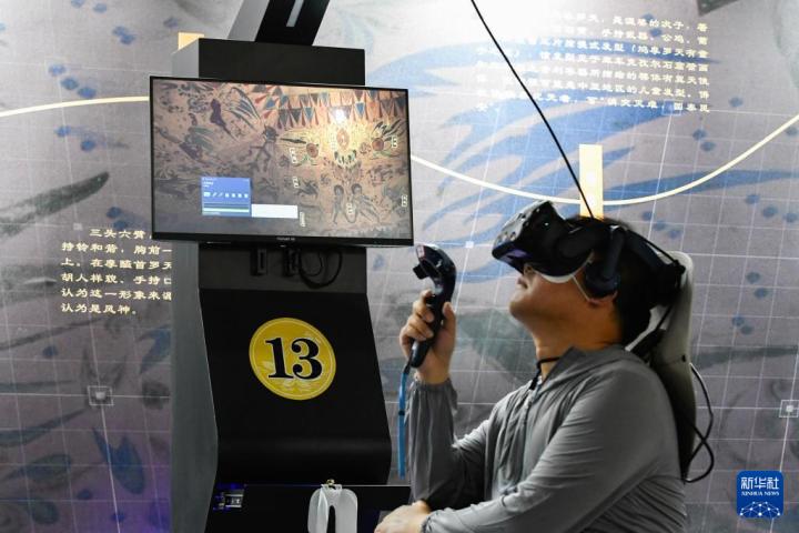 7月22日，游客借助VR設備沉浸式游覽莫高窟第285窟虛擬場景。新華社記者 郎兵兵 攝